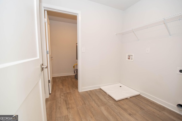 clothes washing area with hookup for an electric dryer, hookup for a washing machine, and light hardwood / wood-style flooring