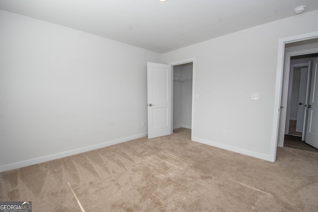 unfurnished bedroom with light carpet and a closet