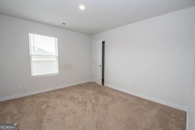 unfurnished room featuring light carpet