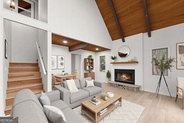 living area featuring beam ceiling, stairway, high vaulted ceiling, light wood-type flooring, and wooden ceiling