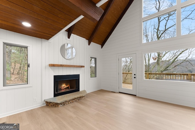 unfurnished living room with a large fireplace, wood finished floors, high vaulted ceiling, wooden ceiling, and beamed ceiling