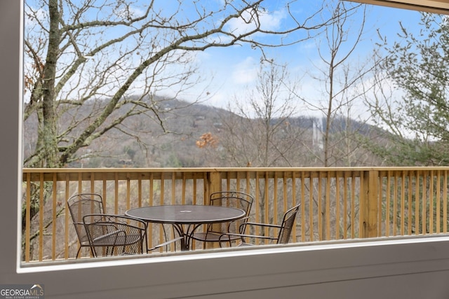 wooden terrace featuring outdoor dining area and a mountain view