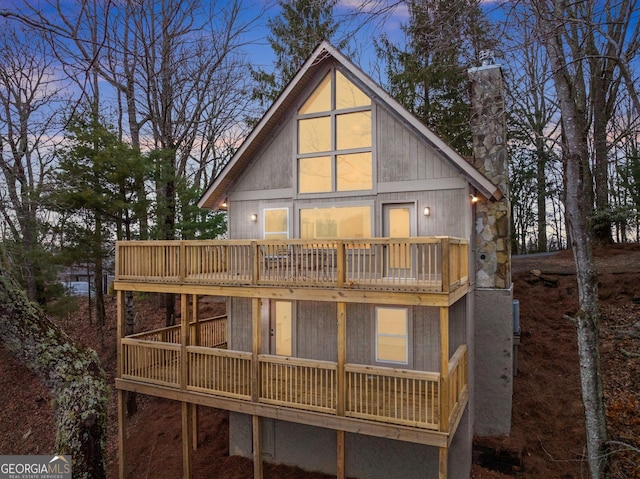 back house at dusk featuring a balcony