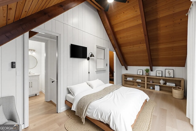 bedroom featuring vaulted ceiling with beams, wooden ceiling, light wood-style flooring, and ensuite bathroom