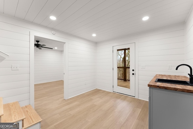 interior space featuring sink, wood ceiling, wooden counters, and light wood-type flooring