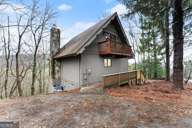 exterior space with cooling unit, a balcony, and a deck