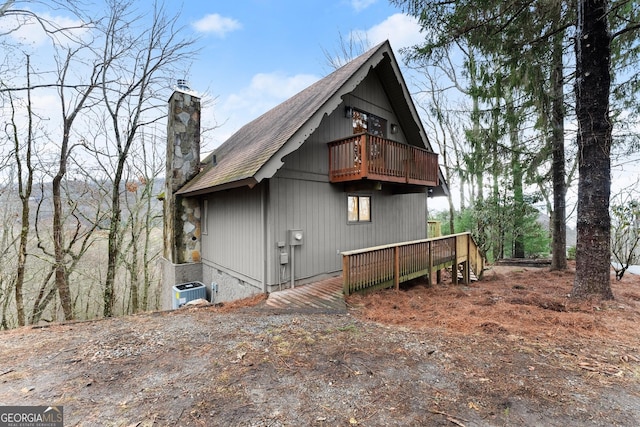 view of front of property with roof with shingles, a chimney, crawl space, central AC, and a wooden deck