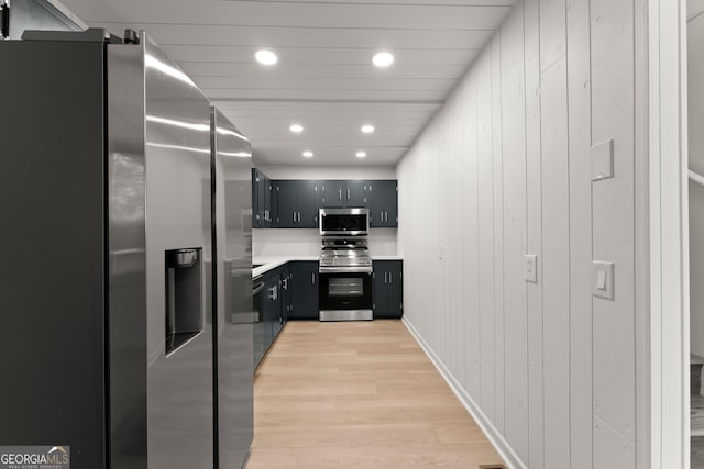 kitchen with stainless steel appliances, recessed lighting, light countertops, light wood-style flooring, and dark cabinets