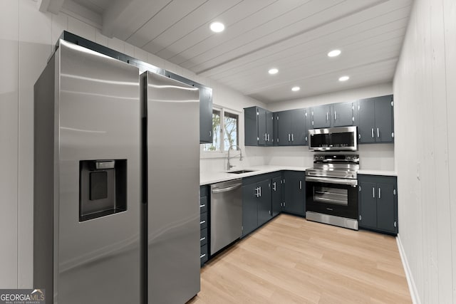 kitchen with recessed lighting, light countertops, appliances with stainless steel finishes, a sink, and light wood-type flooring