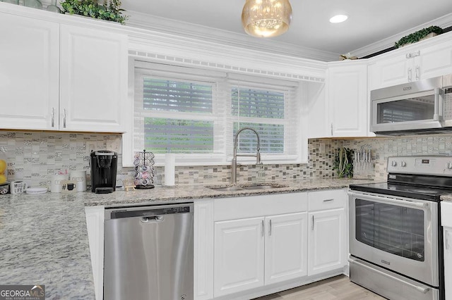 kitchen featuring stainless steel appliances, white cabinetry, sink, and crown molding