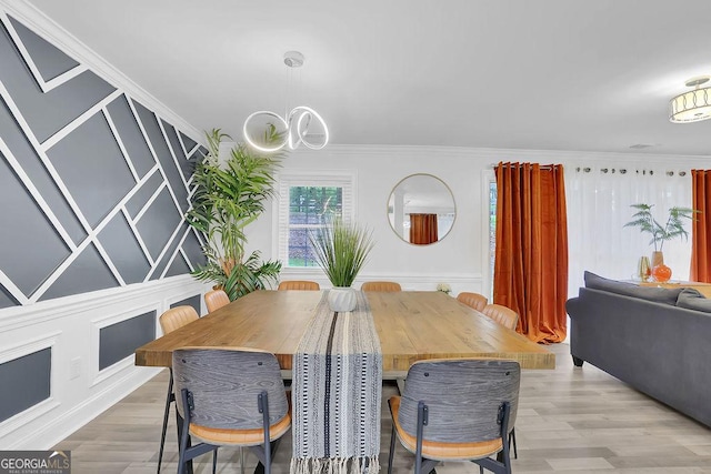 dining room with an inviting chandelier, ornamental molding, and wood-type flooring