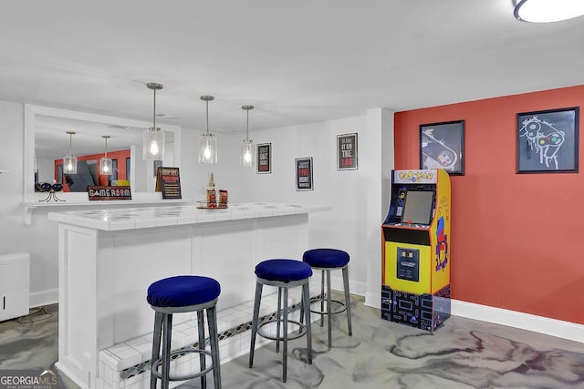 bar with pendant lighting, concrete flooring, and white cabinets