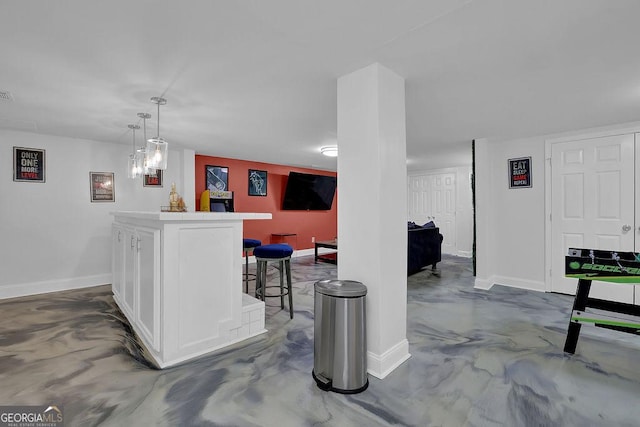 bar featuring decorative light fixtures and white cabinets