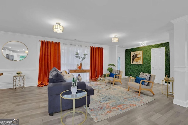 living room with light hardwood / wood-style flooring, ornamental molding, and decorative columns