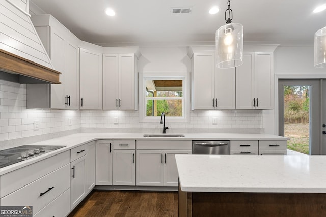 kitchen with sink, custom exhaust hood, white cabinetry, decorative light fixtures, and dishwasher