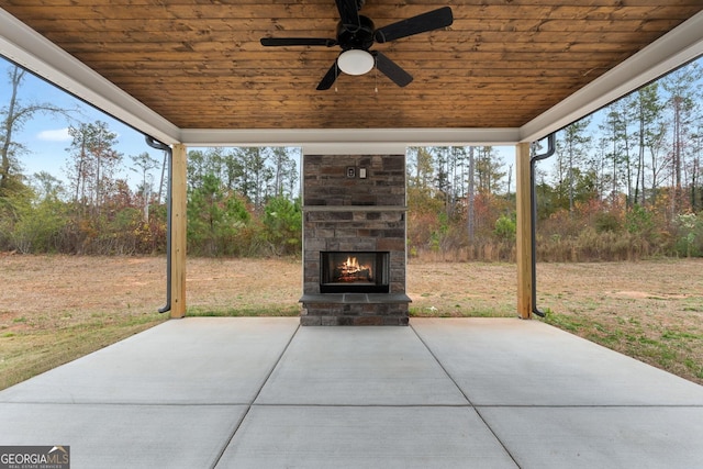 view of patio with exterior fireplace and ceiling fan