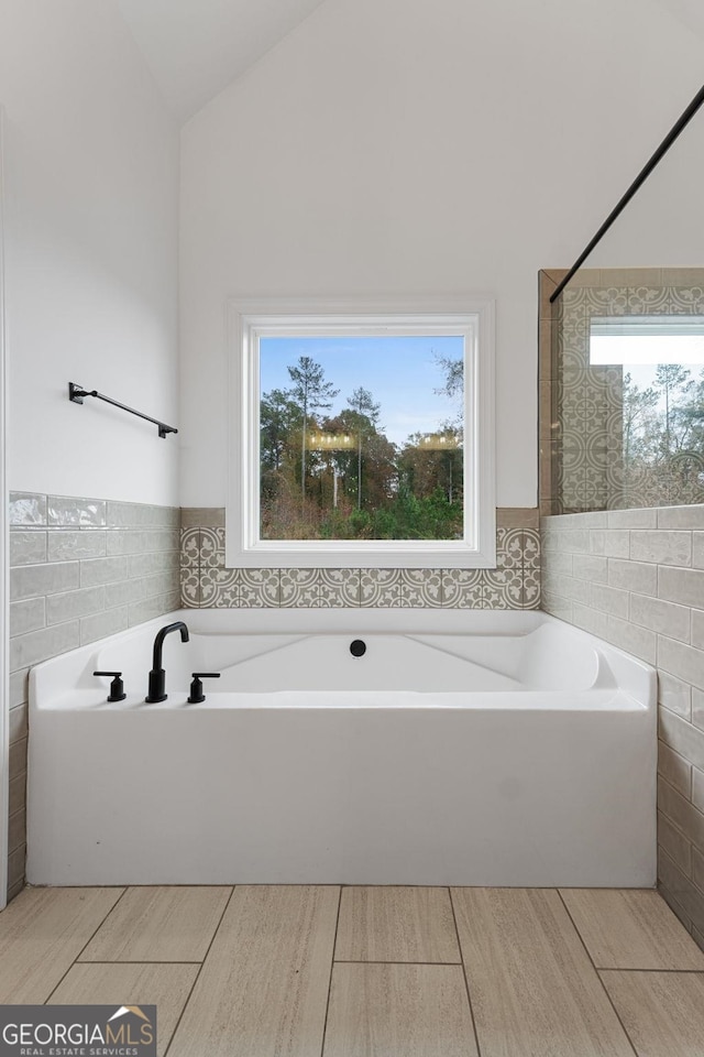 bathroom with tile walls and lofted ceiling