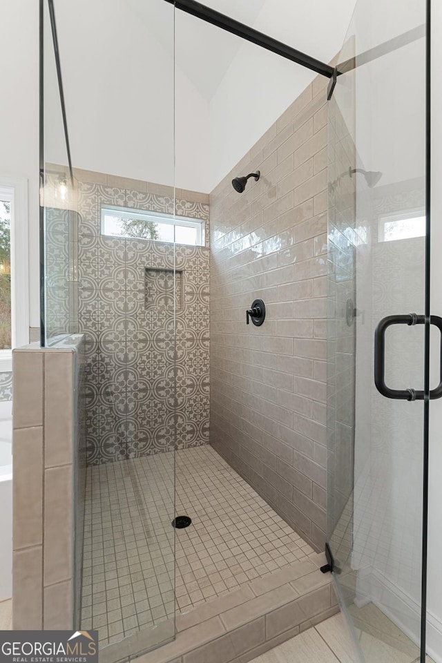 bathroom featuring lofted ceiling and a shower with door