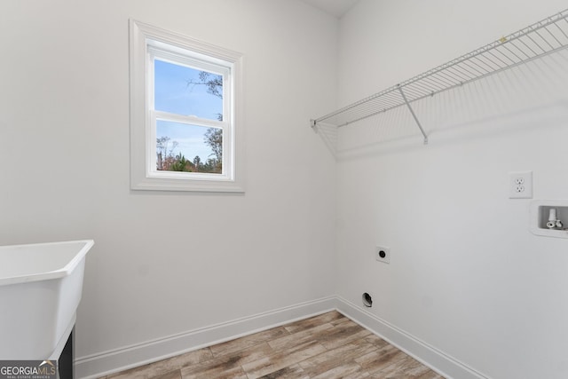 laundry room featuring sink, hookup for a washing machine, light hardwood / wood-style floors, and electric dryer hookup