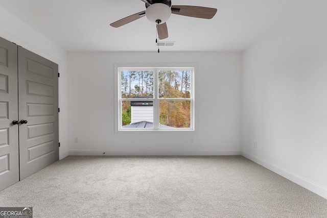 carpeted spare room featuring ceiling fan