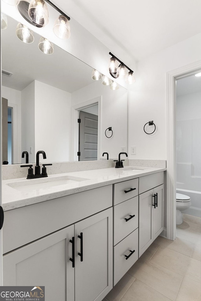 bathroom with tile patterned flooring, vanity, and toilet