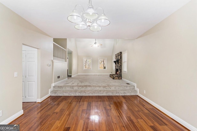 interior space with lofted ceiling, hardwood / wood-style floors, and ceiling fan with notable chandelier