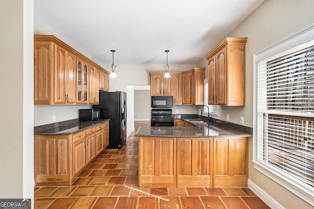 kitchen with sink, decorative light fixtures, kitchen peninsula, dark stone counters, and black appliances