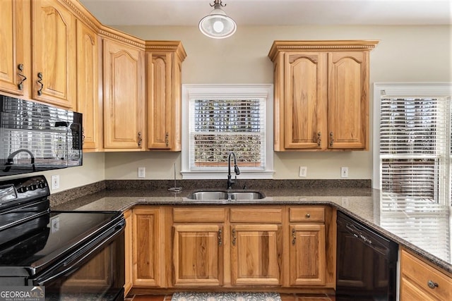 kitchen featuring dark stone countertops, sink, and black appliances