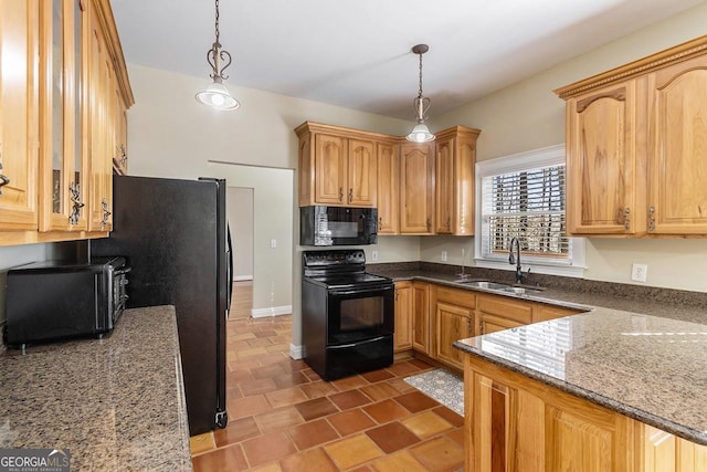 kitchen with sink, decorative light fixtures, black appliances, and stone countertops