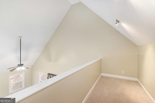 hall with light carpet and vaulted ceiling