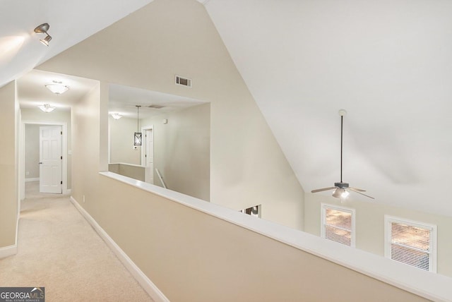 hall with light carpet and high vaulted ceiling