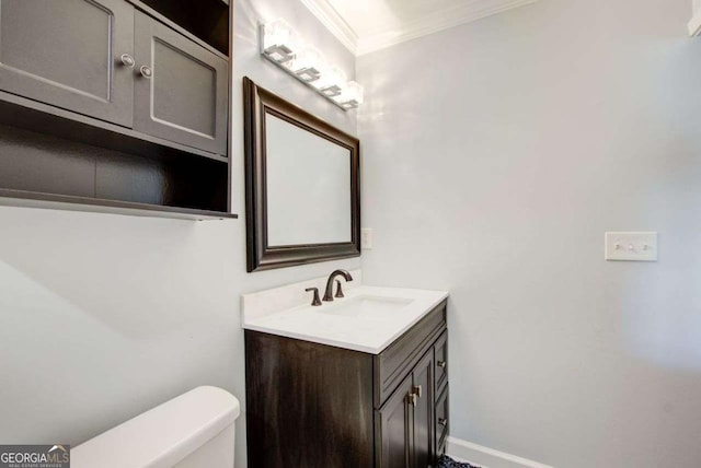 bathroom with vanity, ornamental molding, and toilet