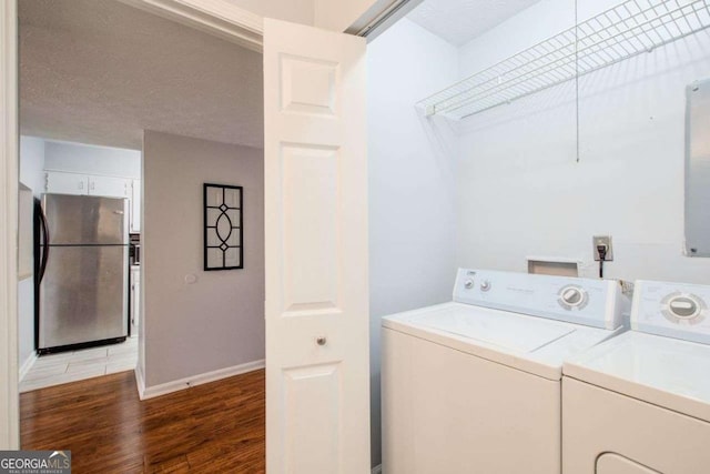 laundry area with washer and clothes dryer, dark hardwood / wood-style floors, and a textured ceiling