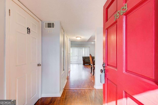 foyer entrance featuring hardwood / wood-style flooring and a textured ceiling