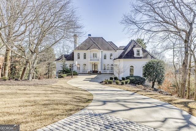 french country style house featuring a front yard and french doors