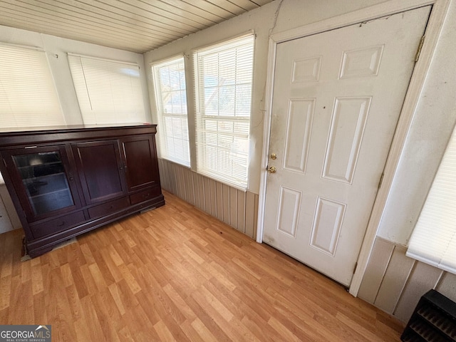 doorway to outside with wooden ceiling, heating unit, and light wood-type flooring