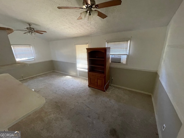 carpeted empty room with cooling unit, ceiling fan, vaulted ceiling, and a textured ceiling