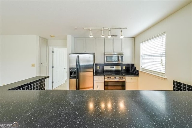 kitchen featuring backsplash, stainless steel appliances, and white cabinets