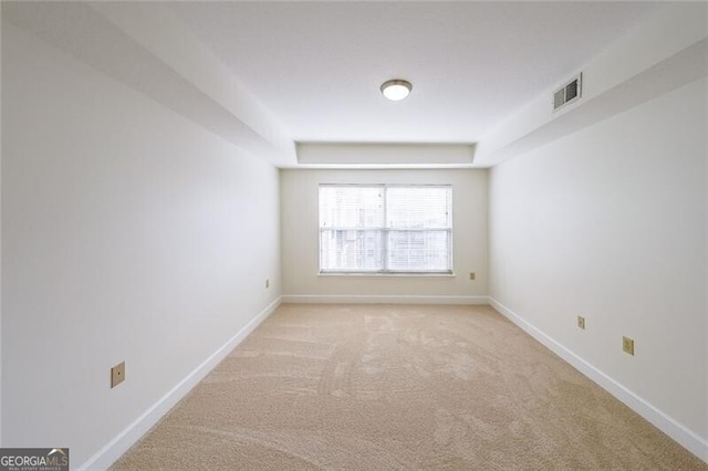 spare room featuring light colored carpet