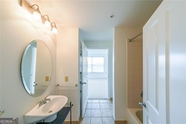 bathroom featuring tiled shower / bath, tile patterned flooring, and sink