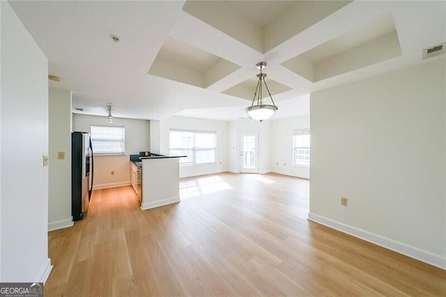 kitchen featuring coffered ceiling, hanging light fixtures, stainless steel fridge, and light hardwood / wood-style floors