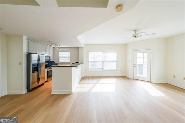 kitchen with plenty of natural light, light hardwood / wood-style floors, ceiling fan, and appliances with stainless steel finishes