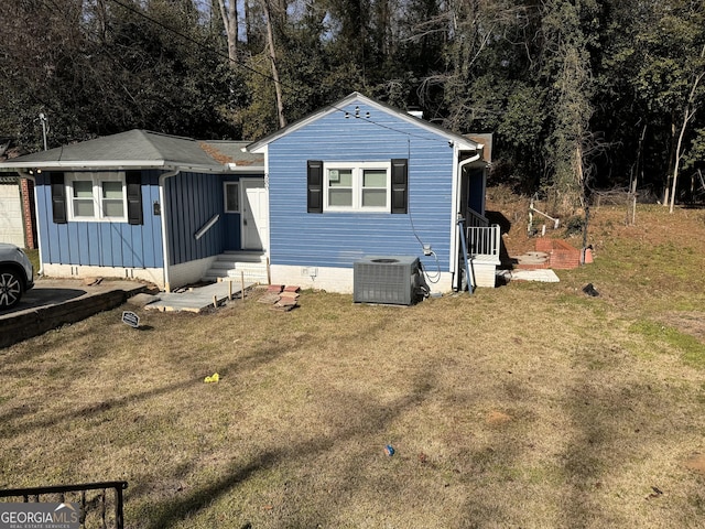 view of front of property with central AC unit and a front yard