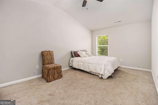 bedroom with ceiling fan, light colored carpet, and vaulted ceiling