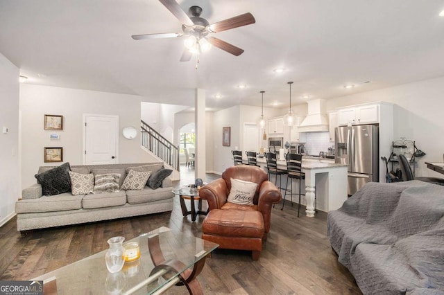 living room featuring dark wood-type flooring and ceiling fan