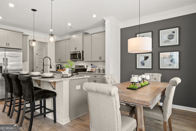 kitchen featuring appliances with stainless steel finishes, gray cabinets, and hanging light fixtures