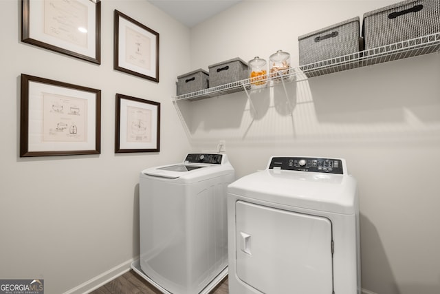 clothes washing area with dark wood-type flooring and washer and clothes dryer