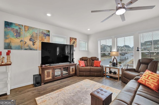 living room featuring wood-type flooring and ceiling fan