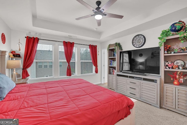 bedroom featuring a raised ceiling, carpet floors, and ceiling fan