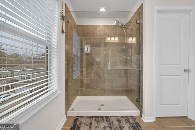 bathroom with walk in shower, tile patterned floors, and a healthy amount of sunlight